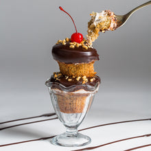 Load image into Gallery viewer, two banana split cupcakes stacked on top of eachother and served in a classic ice cream sundae glass dish not-bg
