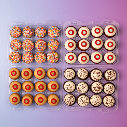 Top view of four flavors of mini dozen cupcakes in clear containers not-bg